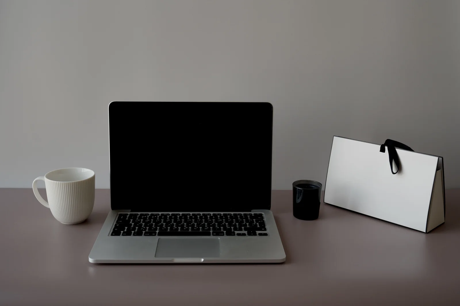 Laptop und Tasse auf einem Schreibtisch